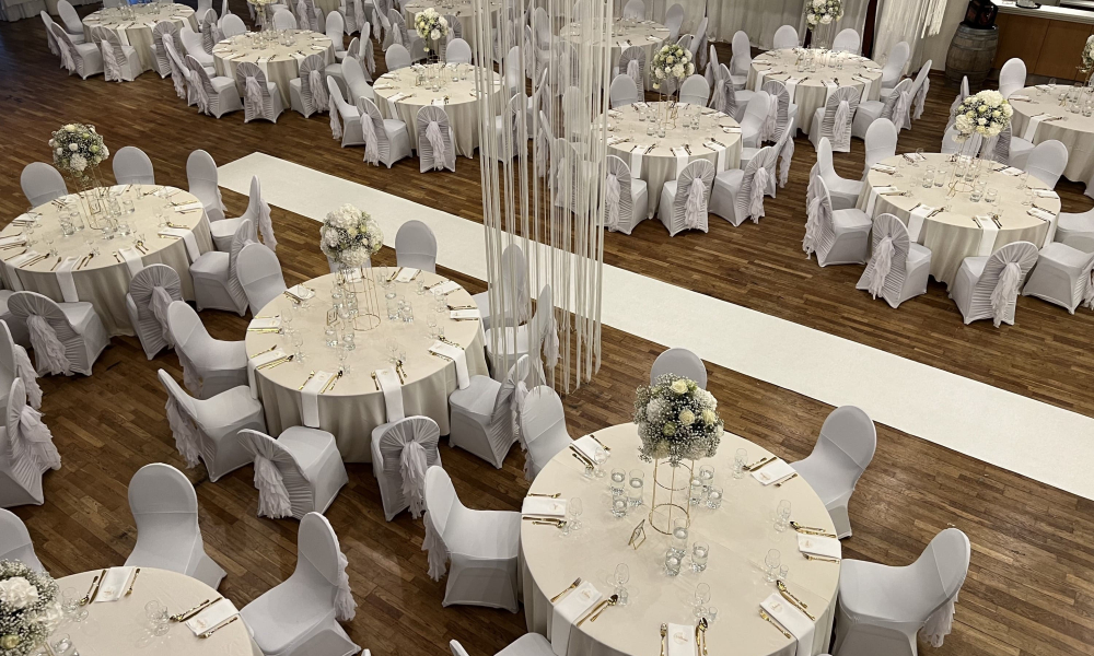 Saal mit vielen weissen Tischen